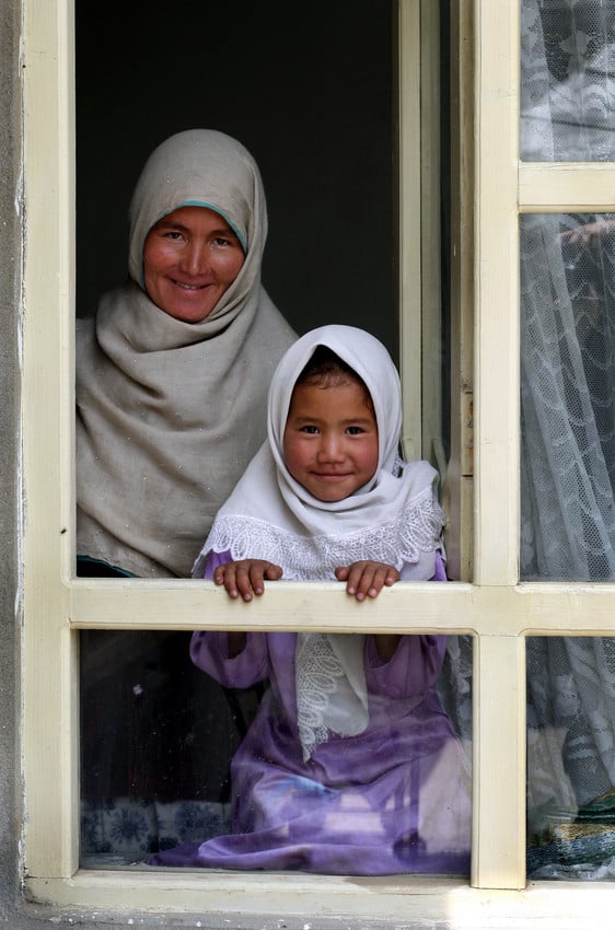 Women Key to Ending Global Poverty -  A muslim woman and child look out a window in Afghanistan. 