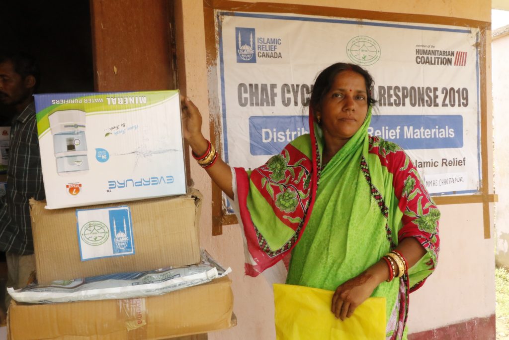 Woman holds her new water purifier received from Humanitarian Coalition