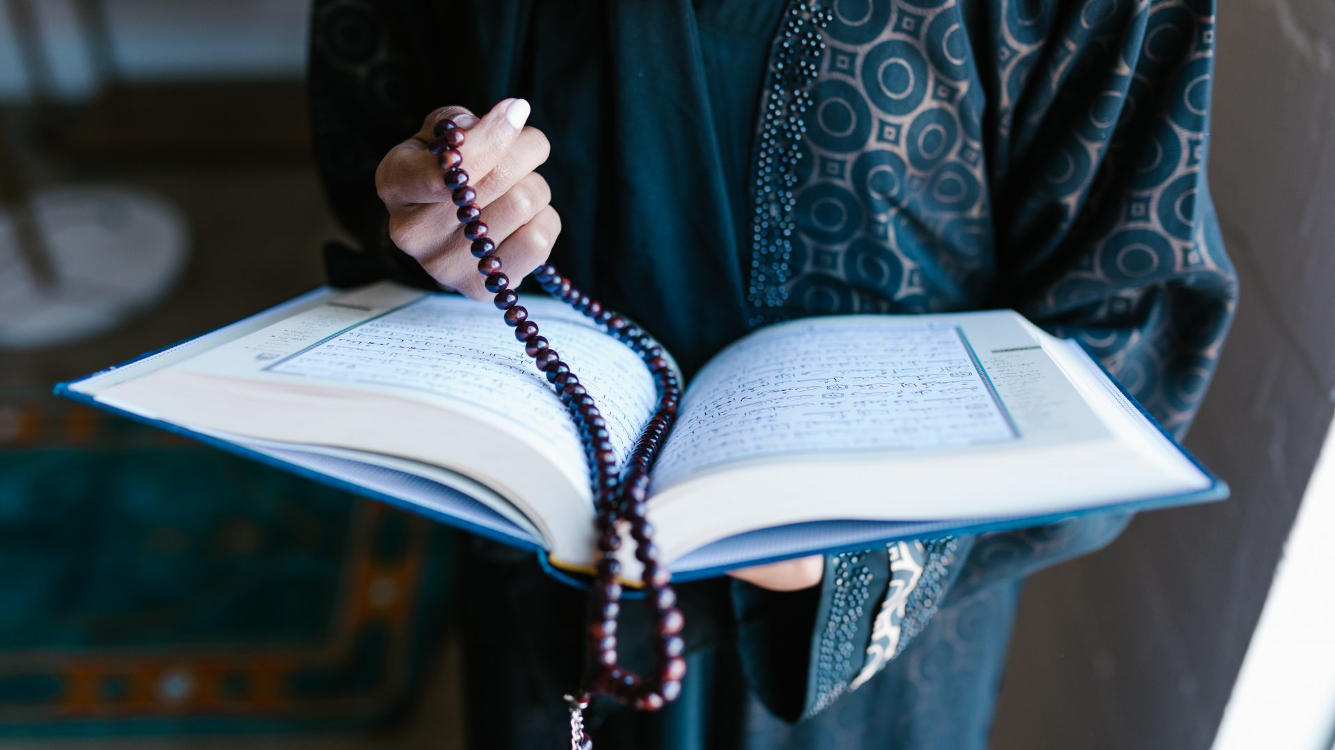 A woman holding an open Quran
